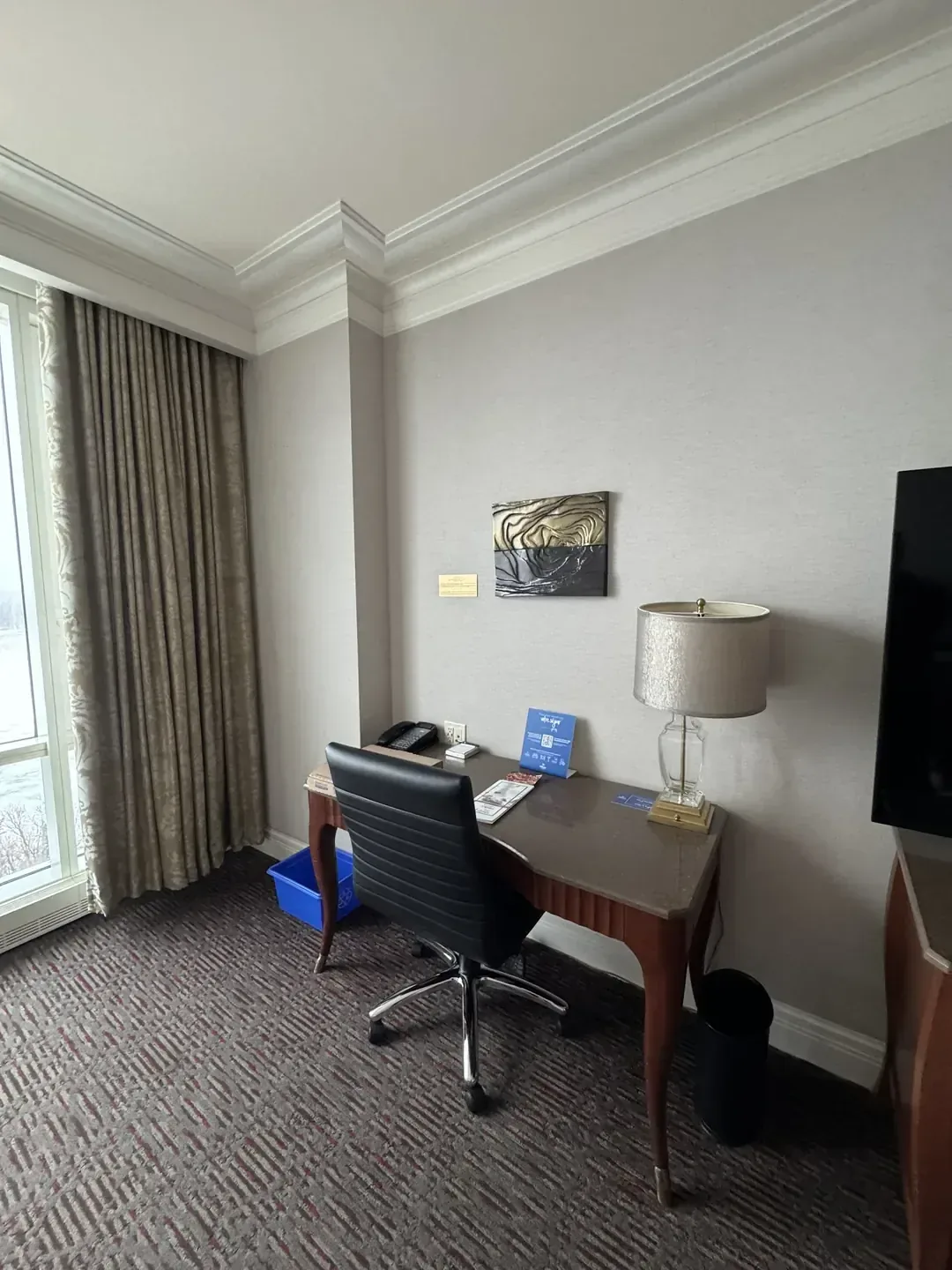 A work desk with a chair and lamp inside a guest room at Hilton Lac-Leamy