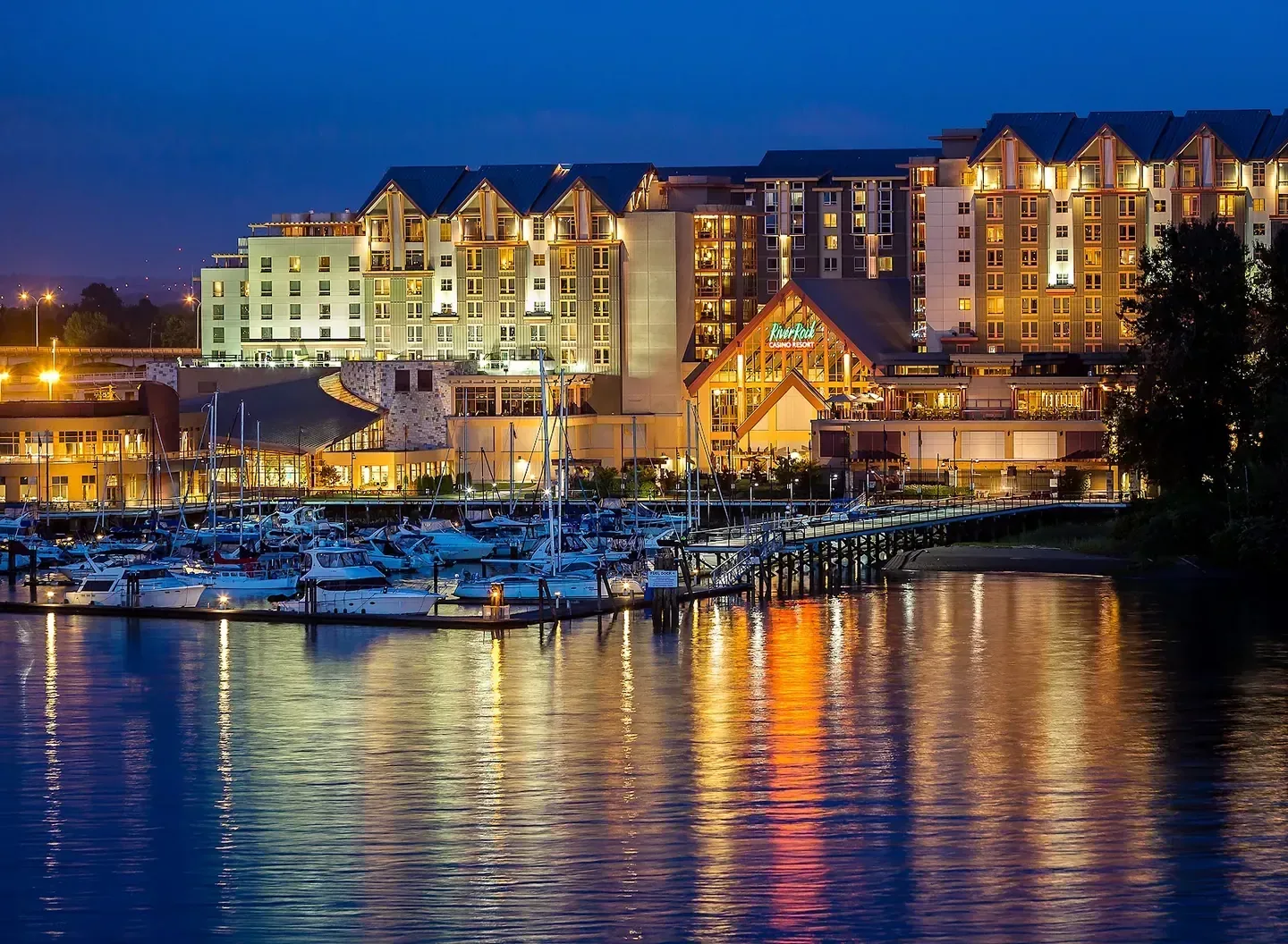 River Rock Casino Resort, Richmond — the resort and its marina lit up at dusk, seen from the water